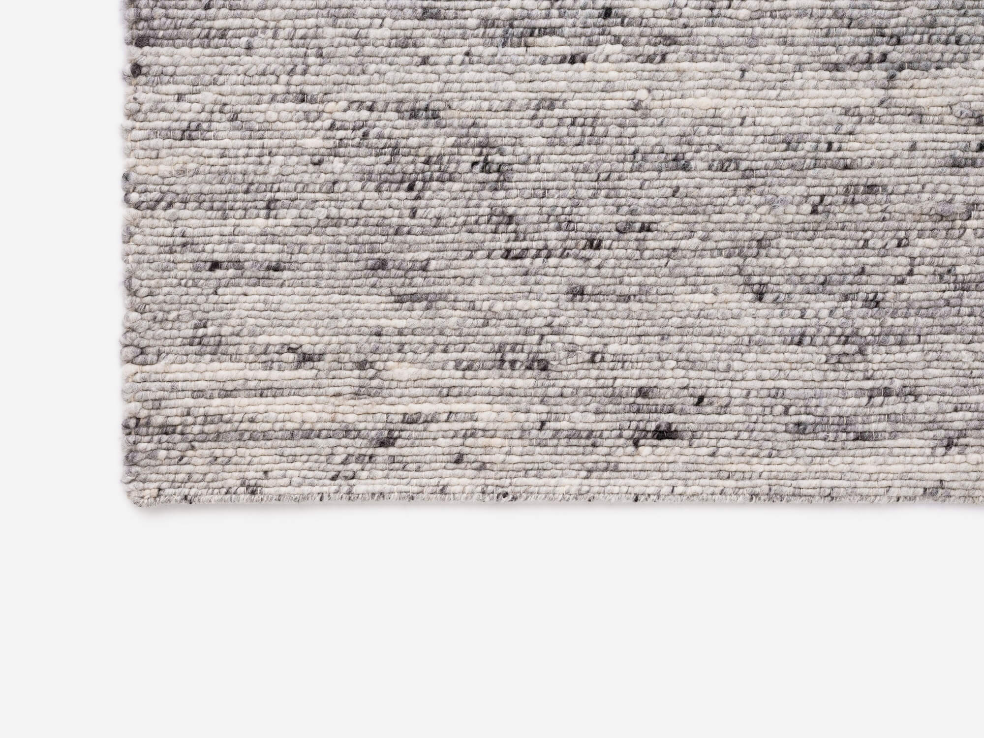 Corner view of light grey living room rug